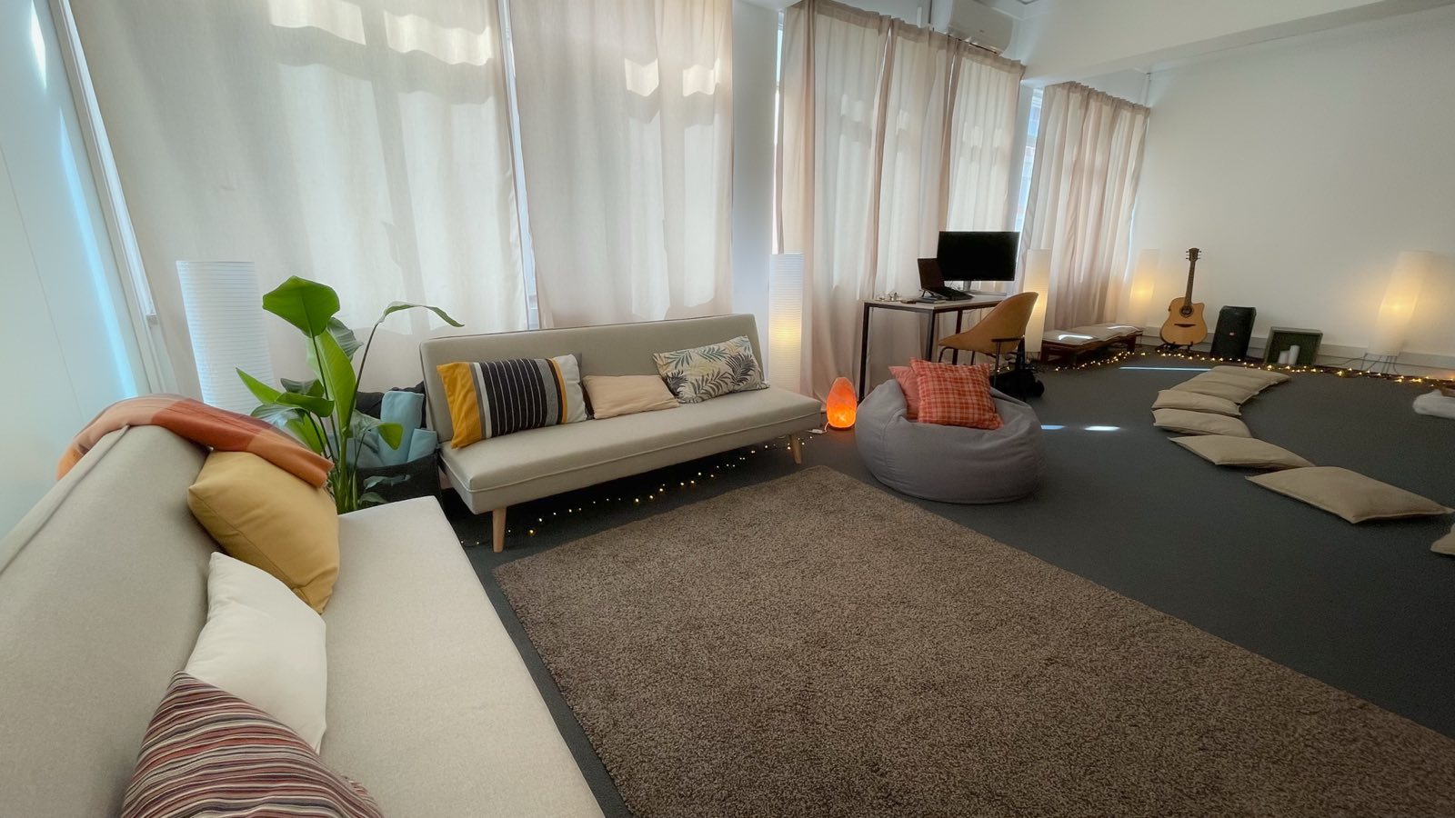 Sala ampla e luminosa da Casa Awen, com sofás e plantas
